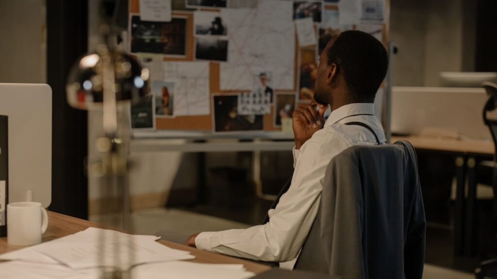 Tablero con fotografías y documentos de casos en investigación privada.